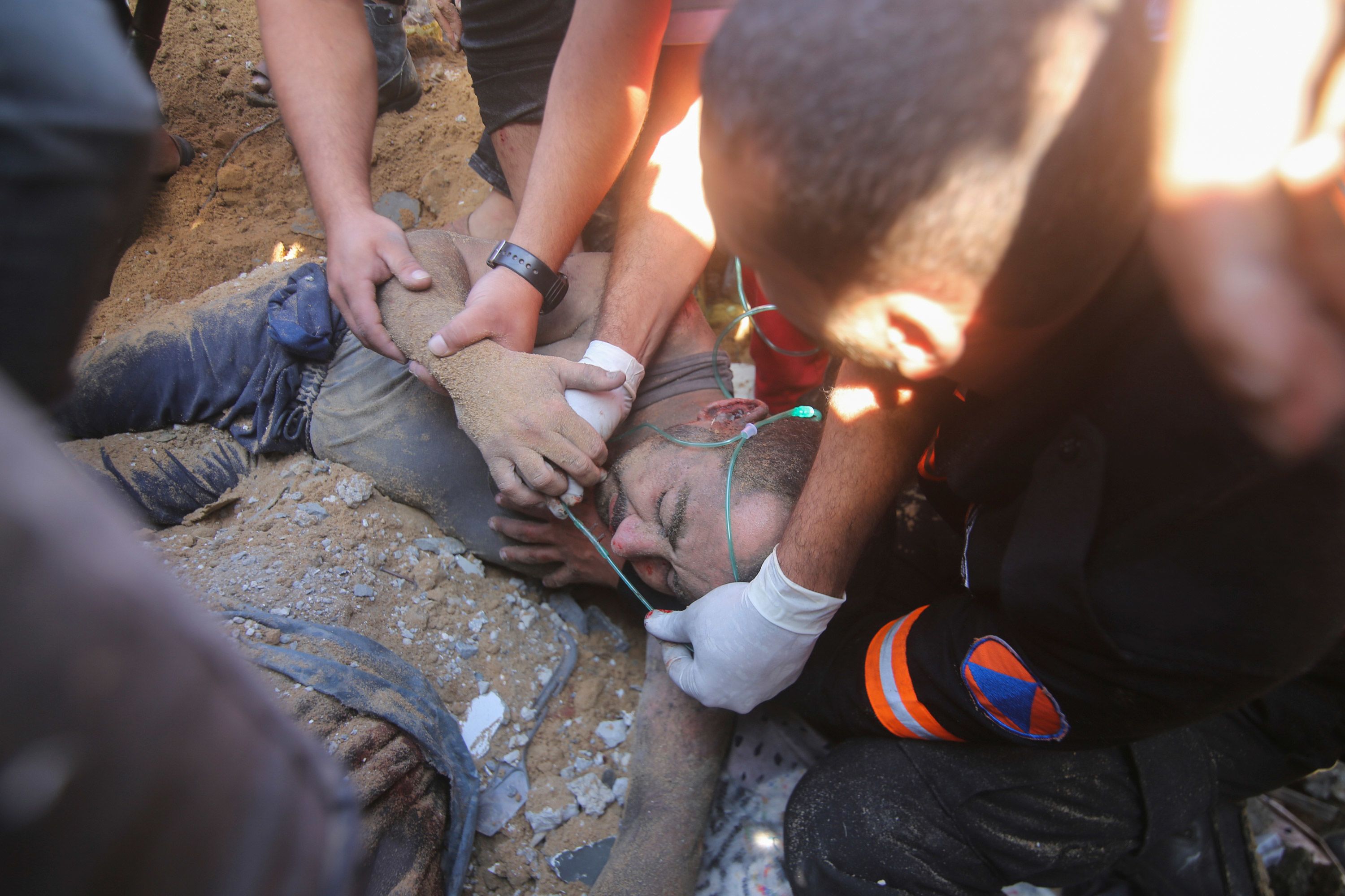 Palestinians rescue a wounded man from the rubble of a destroyed building following an Israeli airstrike in Rafah, Gaza, on October 13.