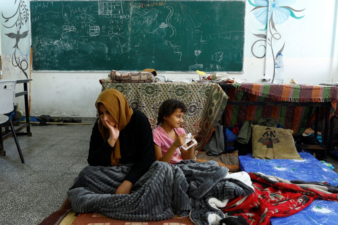 Palestinians, who fled their houses amid Israeli strikes, shelter at a United Nations-run school in Khan Younis in the southern Gaza Strip, October 14.