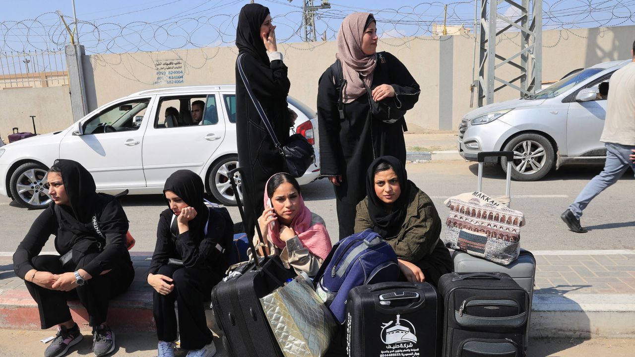 People carrying foreign passports wait at the Rafah gate hoping to cross into Egypt as Israel's attacks on the Gaza Strip continues on October 14, 2023.