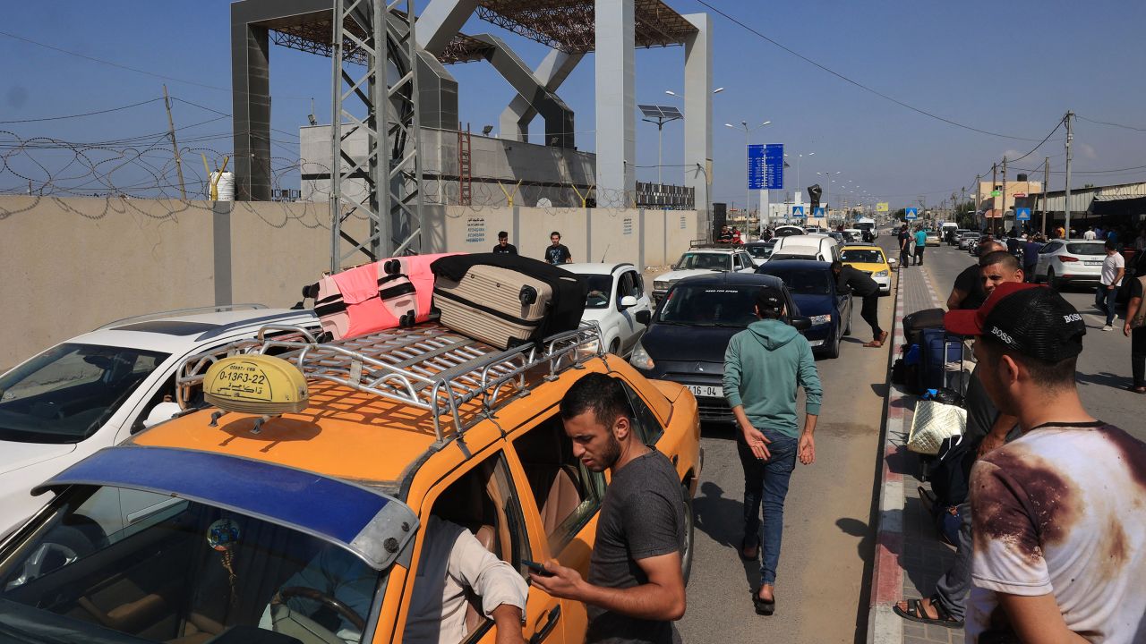 Palestinians with foreign passports arrive at the Rafah gate hoping to cross into Egypt as Israel's attacks on the Gaza Strip continues on October 14..