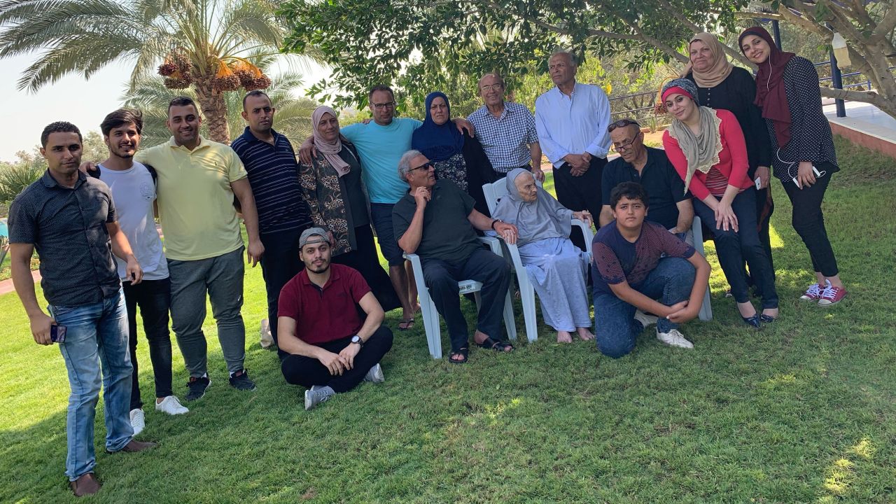 Aref Abou-Amro, in the center back with his arms over sisters, and the rest of the family, including many nephews and nieces, who are trapped in Gaza.