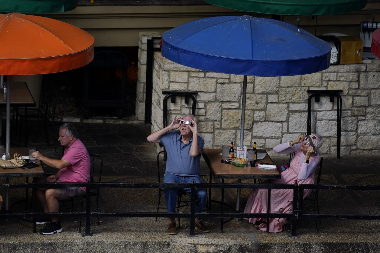 Diners in San Antonio, Texas, observe the eclipse through protective glasses.