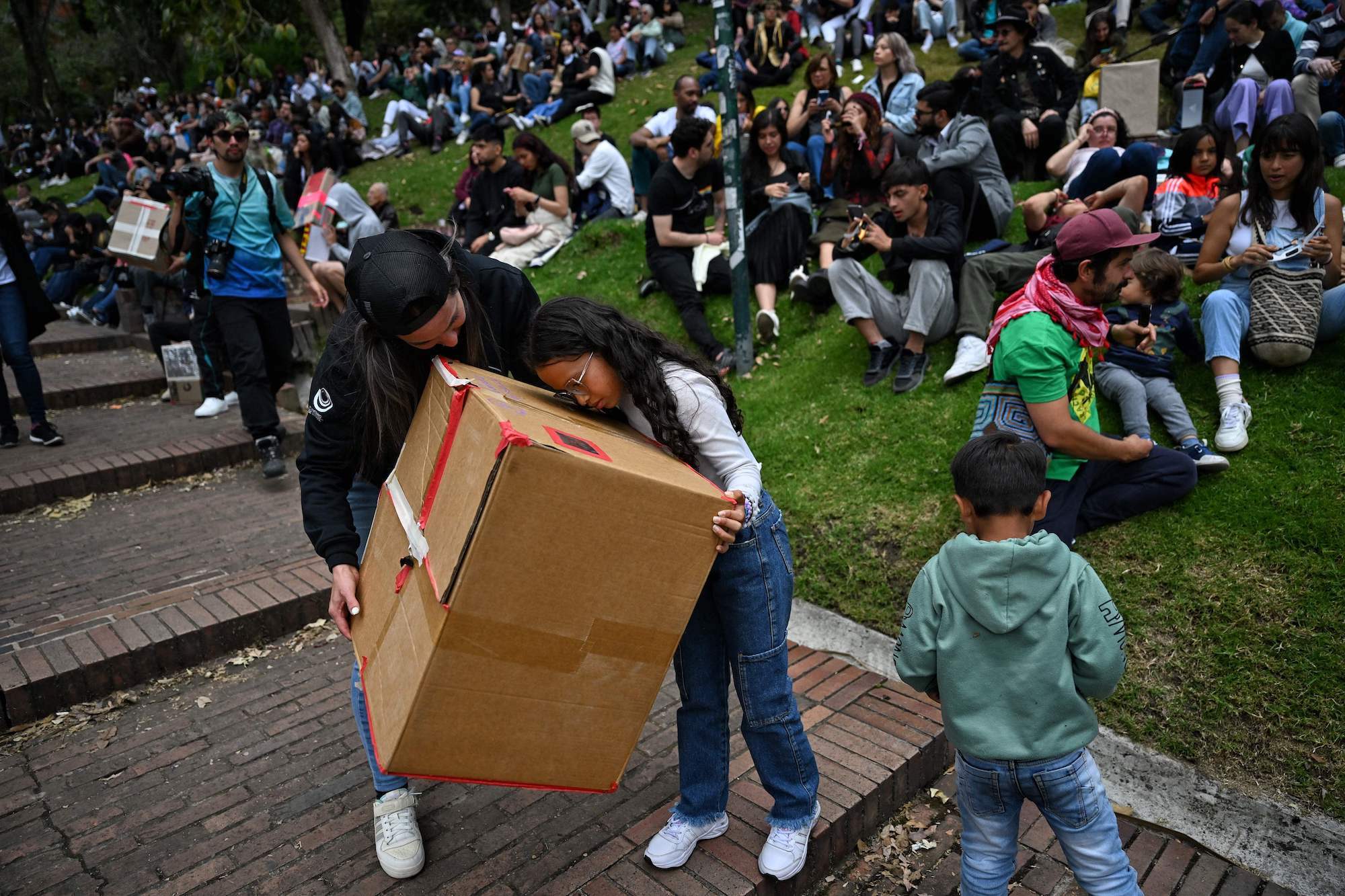 People use a box pinhole projector to watch the annular solar eclipse in Bogota, Colombia.