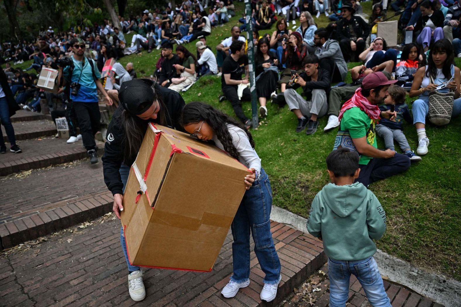 People use a box pinhole projector to watch the annular solar eclipse in Bogota, Colombia.