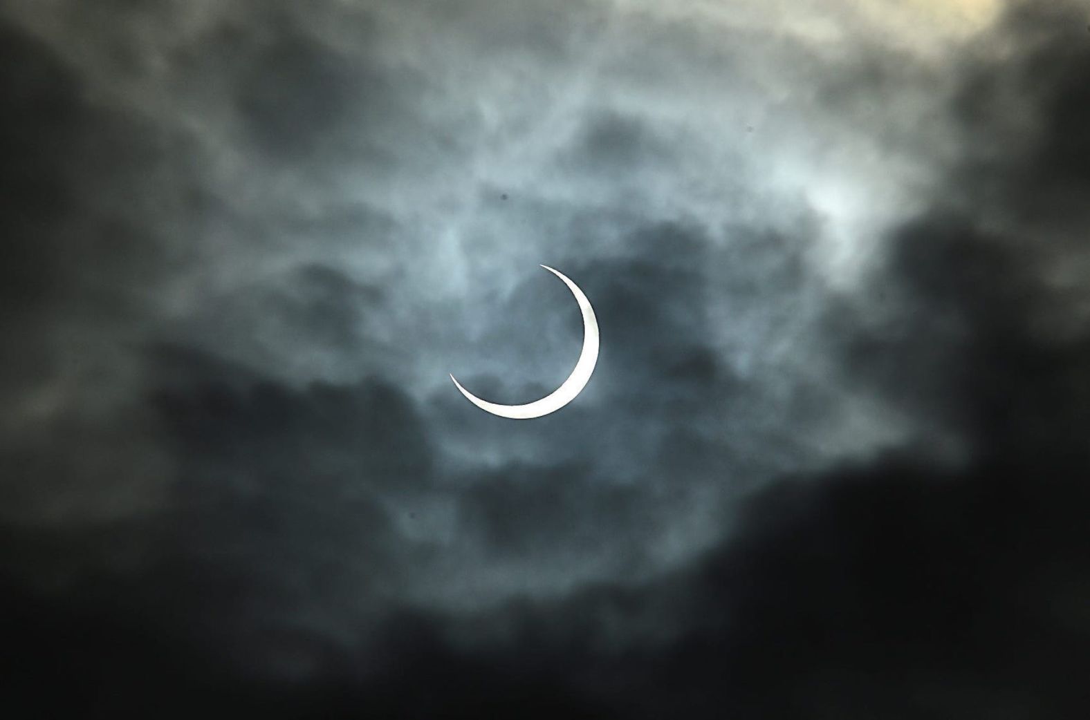 The eclipse pokes through the clouds during a watch party at the Fleischmann Planetarium in Reno, Nevada.