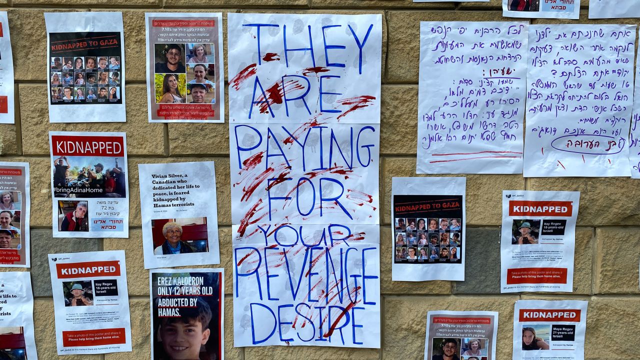 Pictures of people who have been kidnapped by Hamas are displayed on a wall alongside protest slogans in Tel Aviv on Saturday, October 14, 2023