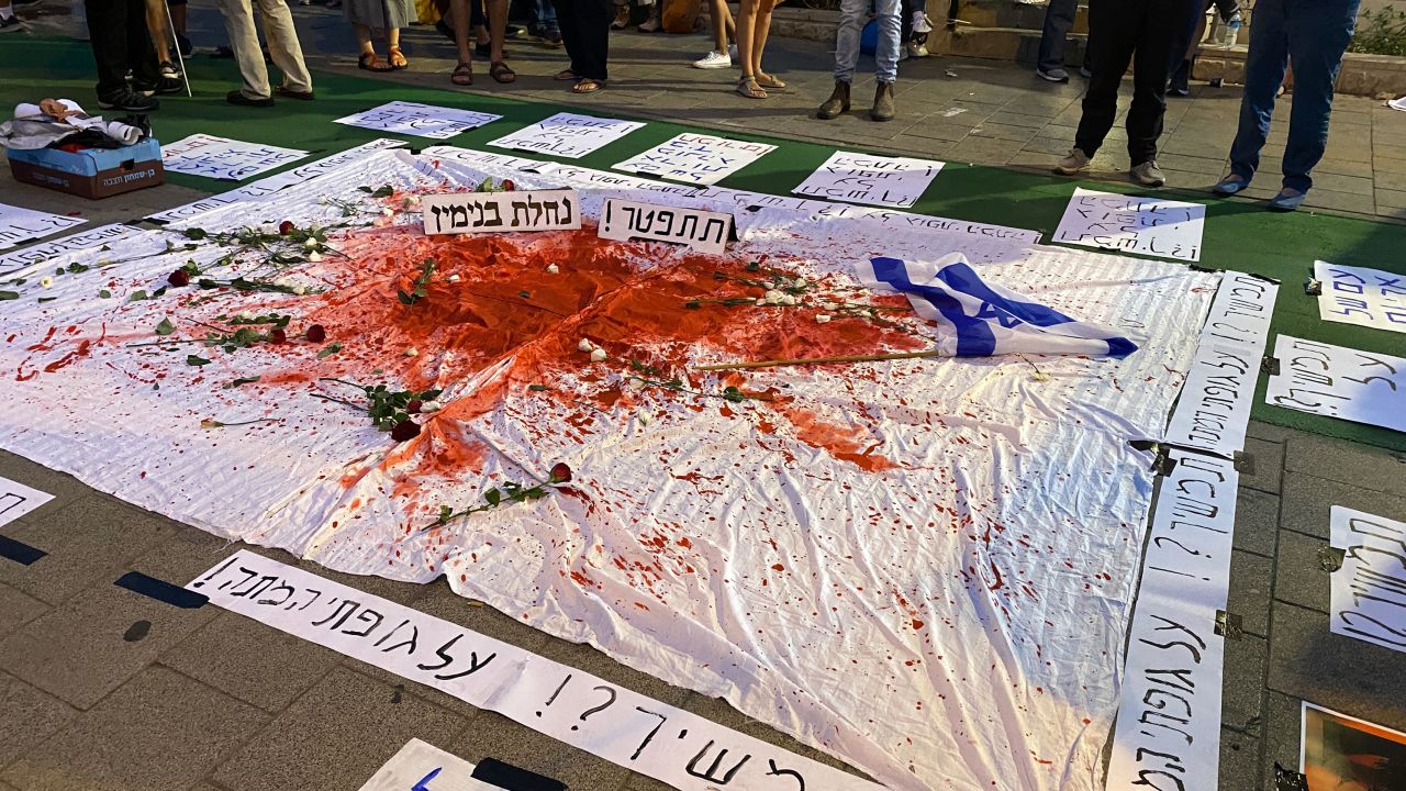 A sign that says "Continue? Over my dead body" is seen at a protest against Benjamin Netanyahu in Tel Aviv on Saturday, October 14, 2023