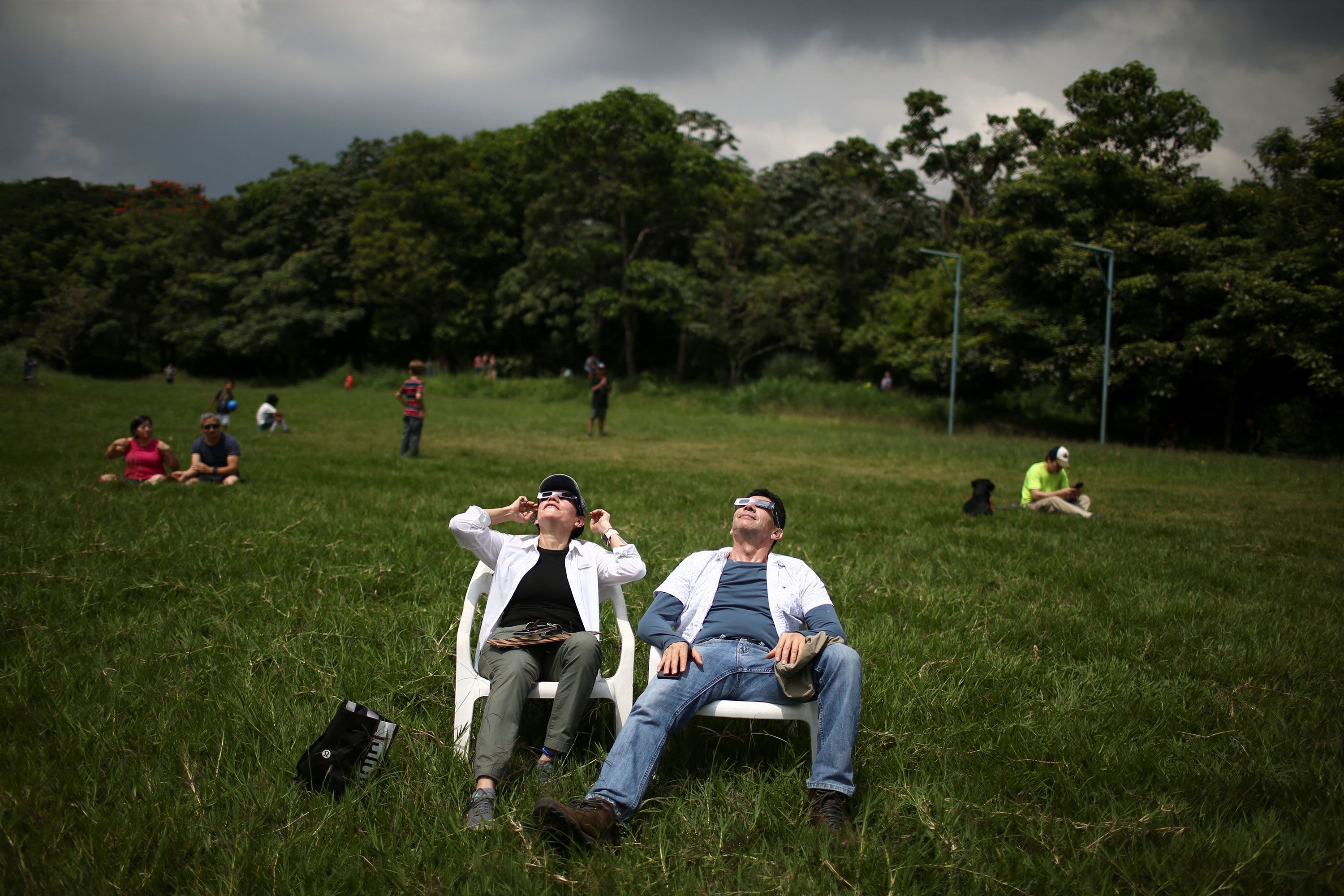 People observe the solar eclipse from Bicentenario Park in Antiguo Cuscatlán, El Salvador.