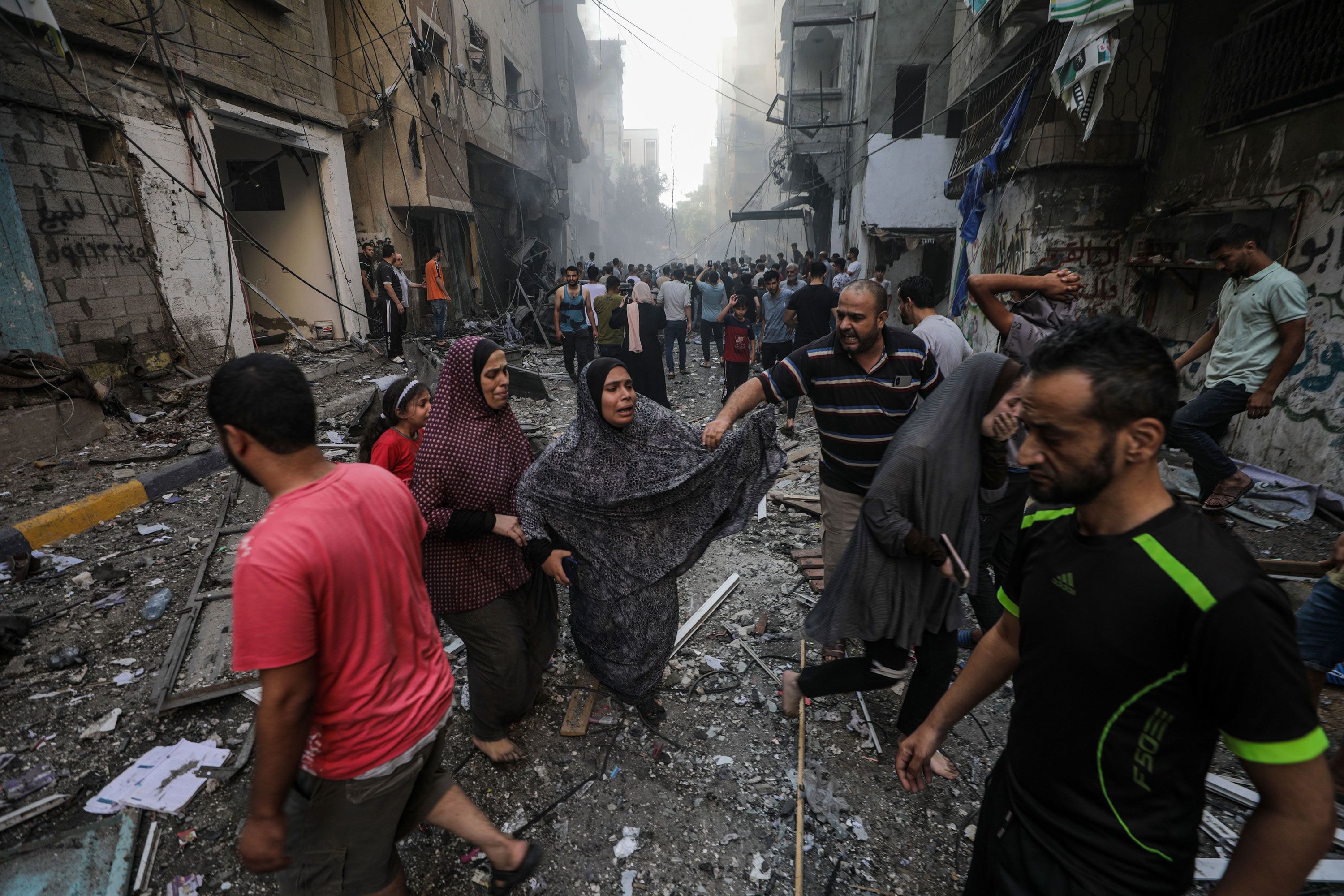 People react at the site of an Israeli airstrike in Al-Shati refugee camp in Gaza City on Saturday, October 14.