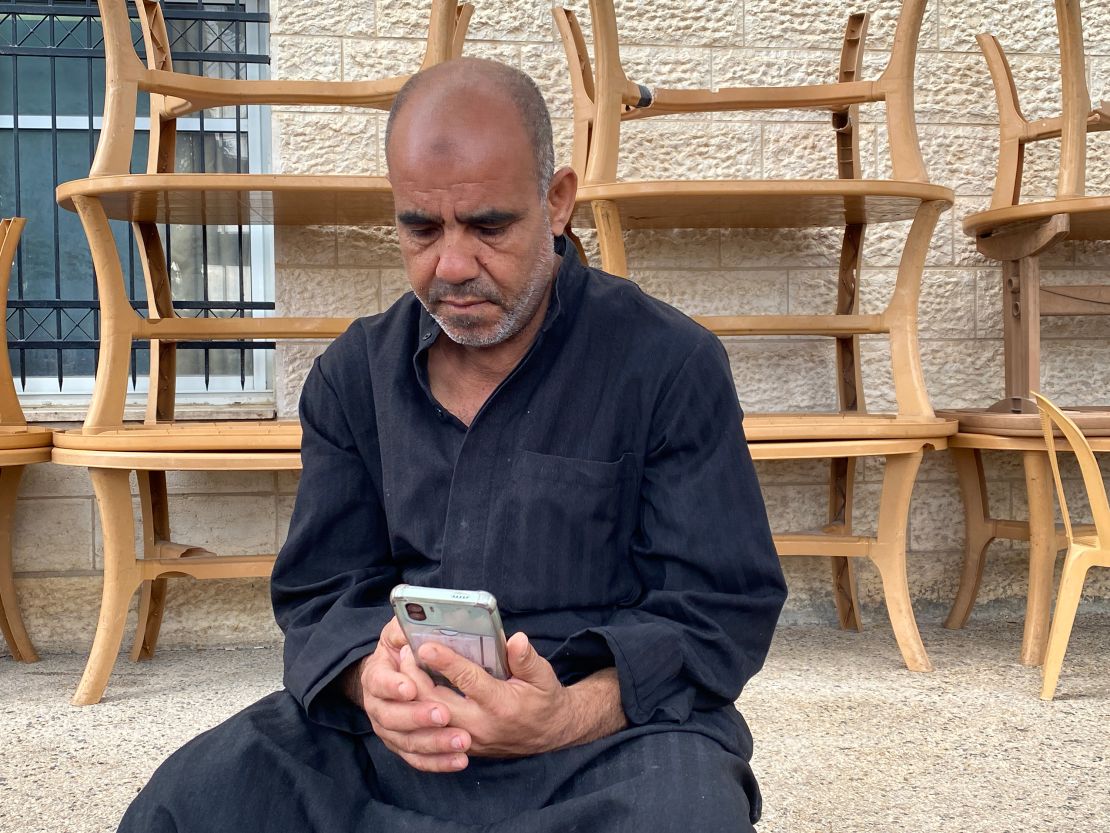Marwan Saqer looks at his phone as his family tries to call him from Gaza, but fails to get through.