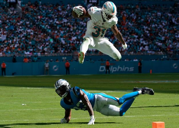 Miami Dolphins running back Raheem Mostert jumps over Carolina Panthers cornerback CJ Henderson on October 15. Mostert had two touchdowns during the Dolphins' 42-21 victory.