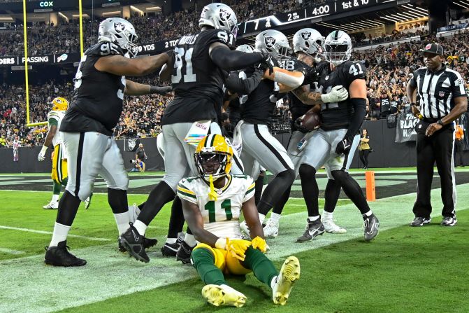 Green Bay Packers wide receiver Jayden Reed sits on the sideline as Las Vegas Raiders' Robert Spillane is congratulated after his interception on Monday, October 9. The Raiders beat the Packers 17-13. 