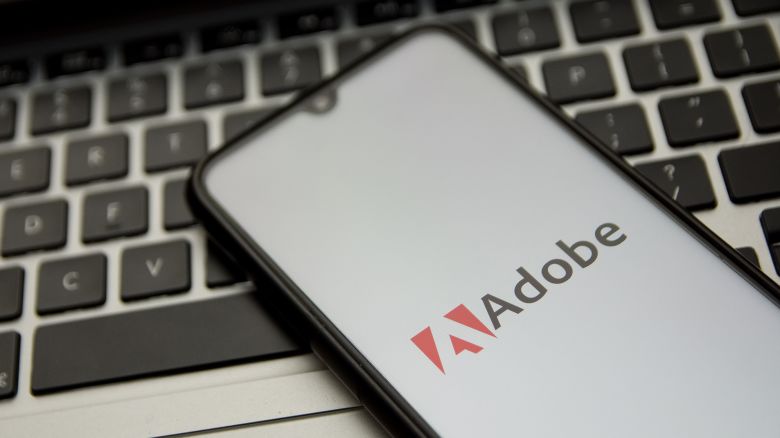 In this photo illustration an Adobe logo seen displayed on a smartphone screen with a computer keyword in the background in Athens, Greece on November 18, 2021.