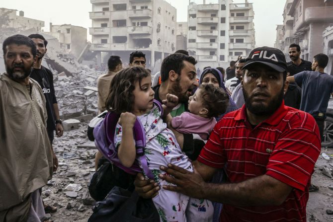 People carry children as they flee following an Israeli strike on Rafah in southern Gaza on Sunday, October 15.