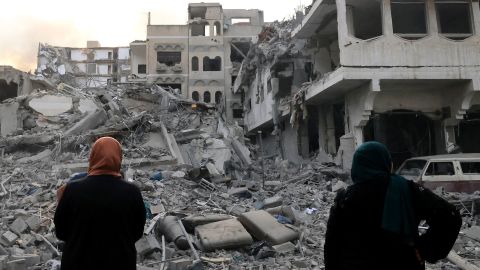 Two Palestinian women look at the massive destruction following Israeli airstrikes on Gaza City's al-Rimal district, on October 10.