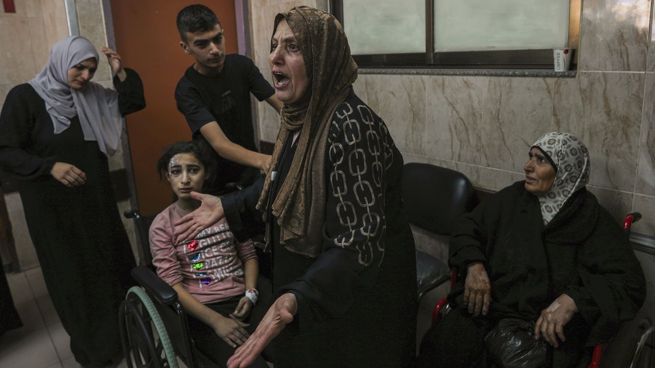 A Palestinian woman reacts to people wounded by Israeli airstriles, at Al-Aqsa hospital, in central Gaza, on October 15.