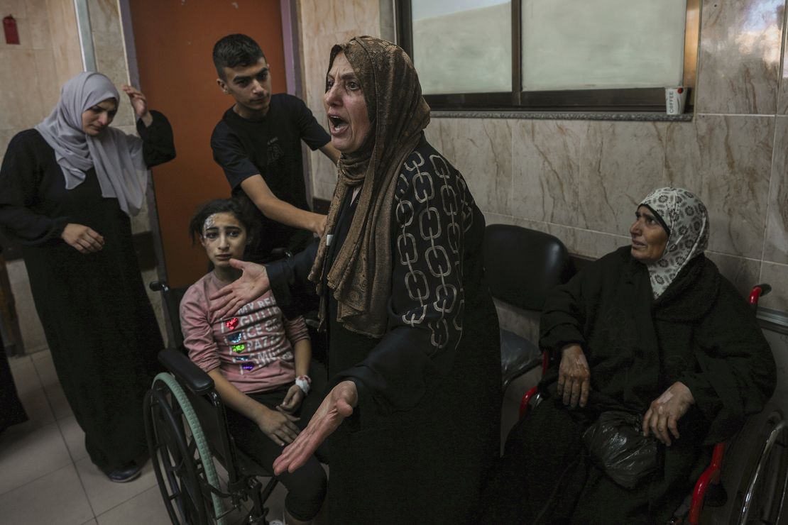 A Palestinian woman reacts to people wounded by Israeli airstriles, at Al-Aqsa hospital, in central Gaza, on October 15.