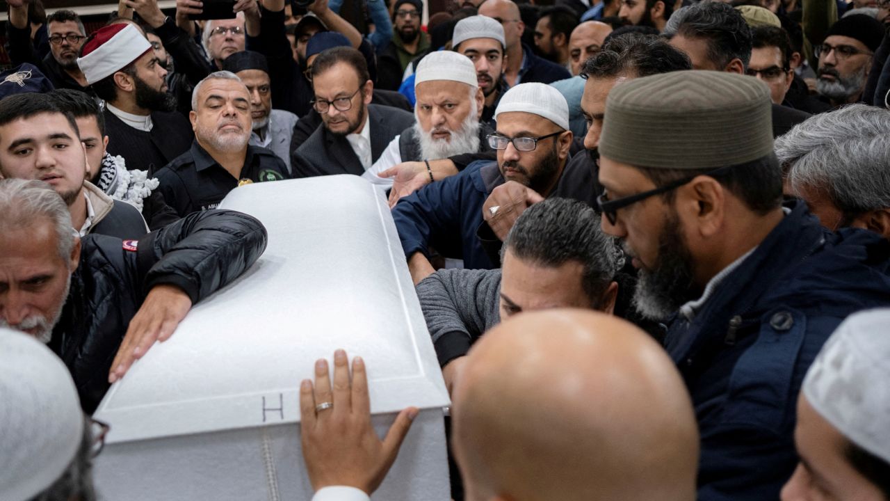 Mourners surround the coffin of Wadea Al-Fayoume carried by her family out of the Mosque Foundation where mourners attended a funeral prayer.