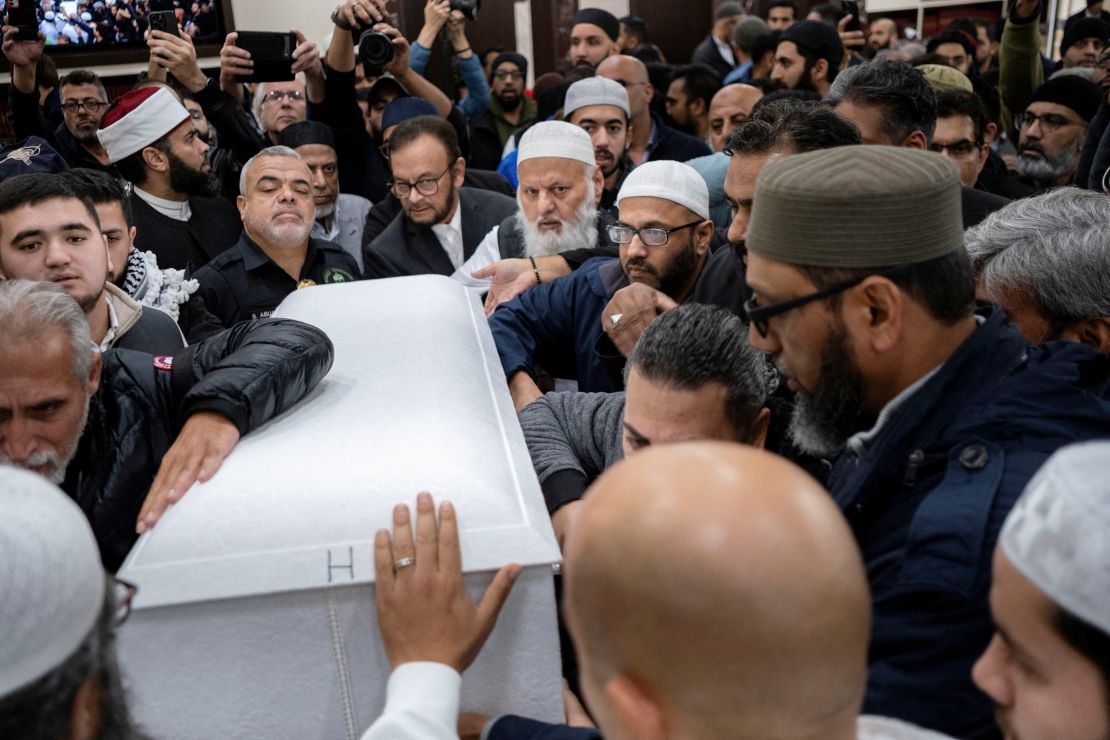 Mourners surround the casket of Wadea Al-Fayoume being carried by his family out of Mosque Foundation where mourners attended a funeral prayer.