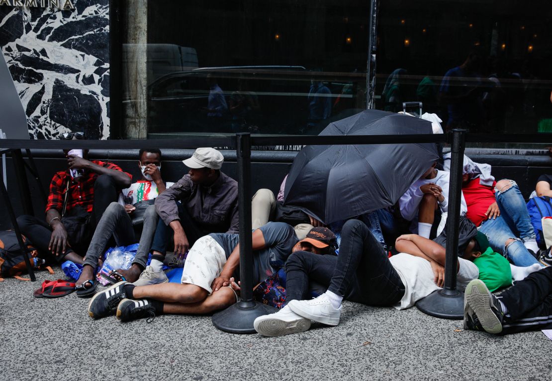 Migrants wait outside the Roosevelt Hotel in midtown Manhattan, New York City, on July 31, 2023. Many newly arrived migrants have been waiting outside the Roosevelt Hotel, which has been turned into a migrant reception center, to try to secure temporary housing. (Photo by KENA BETANCUR / AFP) (Photo by KENA BETANCUR/AFP via Getty Images)