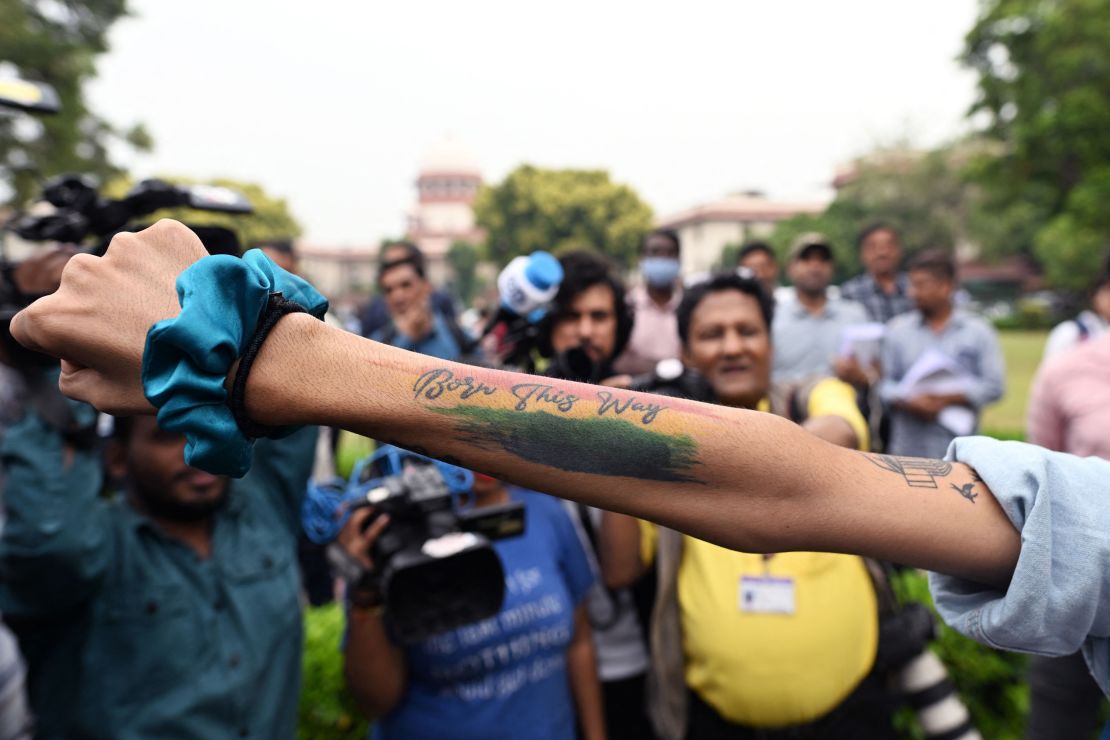 An activist displays a tattoo reading "Born this way" in the courtyard of India's Supreme Court in New Delhi on October 17, 2023. 