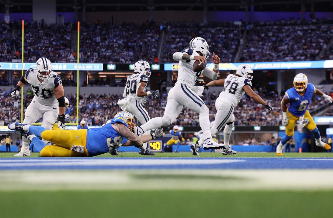 INGLEWOOD, CALIFORNIA - OCTOBER 16: Dak Prescott #4 of the Dallas Cowboys scrambles away from Scott Matlock #99 of the Los Angeles Chargers in the first half at SoFi Stadium on October 16, 2023 in Inglewood, California. (Photo by Kevork Djansezian/Getty Images)