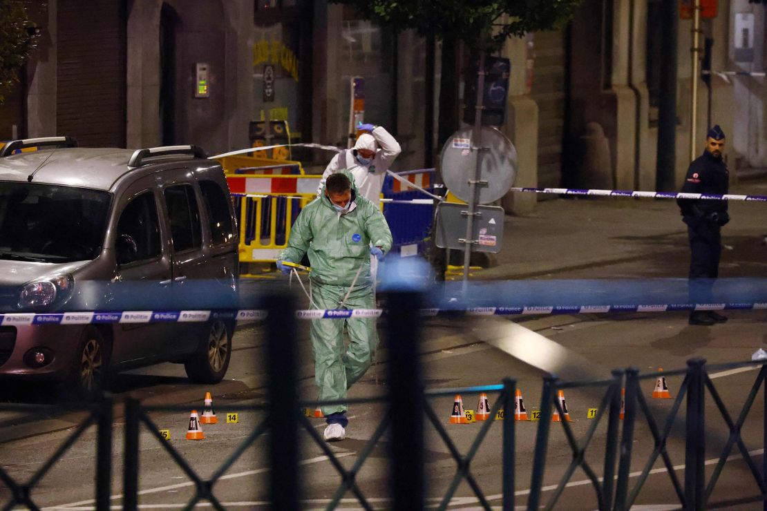 Policiais belgas do serviço forense procuram evidências em uma rua.