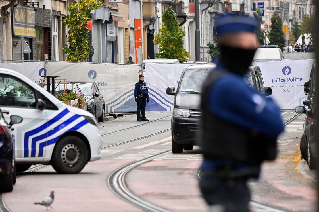 A police officer stands guard in front of a house in the Skarbeek district of Brussels on October 17, 2023. The person believed to be responsible for the attacks in Brussels was shot dead during police intervention.