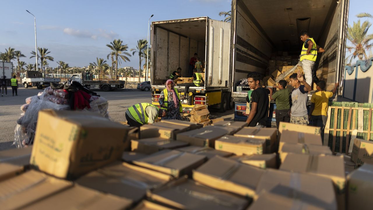 Volunteers load aid trucks with food and supplies on October 16 in North Sinai, Egypt.  Israeli attacks have blocked efforts to bring humanitarian aid into Gaza through the Rafah crossing.