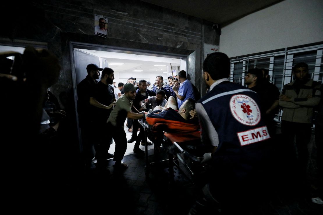 An injured person is assisted after Al-Ahli Baptist Hospital was bombed on Tuesday. 