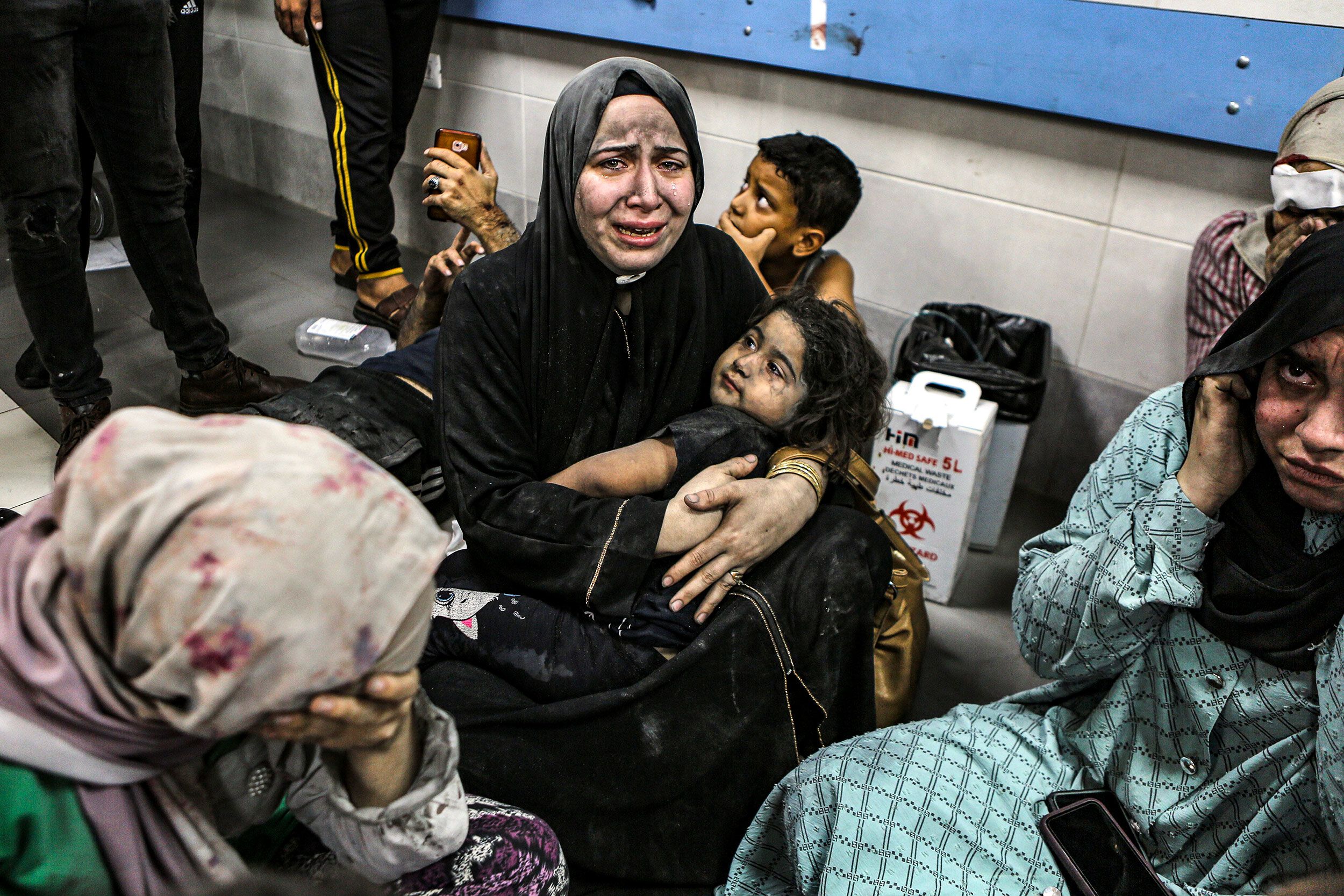 Wounded Palestinians sit on the floor at the Al-Shifa Hospital after being transported from the Al-Ahli Baptist Hospital following a blast there on Tuesday, October 17. 