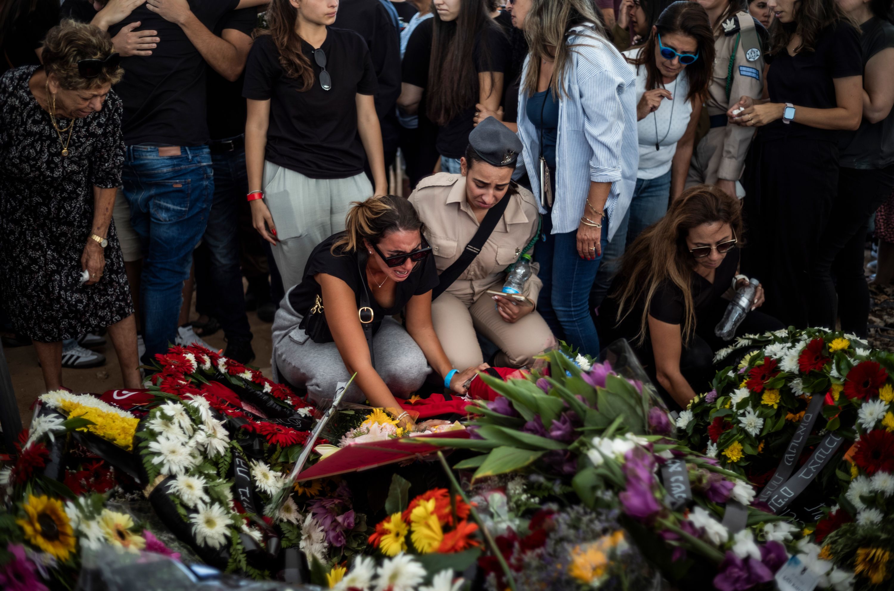 People lay wreaths during a funeral for the Israeli Kutz family in Gan-Yavne, Israel on October 17. The family of five were murdered in their home by Palestinian militants who infiltrated the Israeli Kibbutz of Kfar Aza last week.