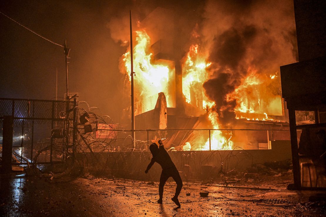 A Lebanese protester hurls stones at a burning building just outside the US Embassy in Beirut during a protest in solidarity with the people of Gaza on October 18.