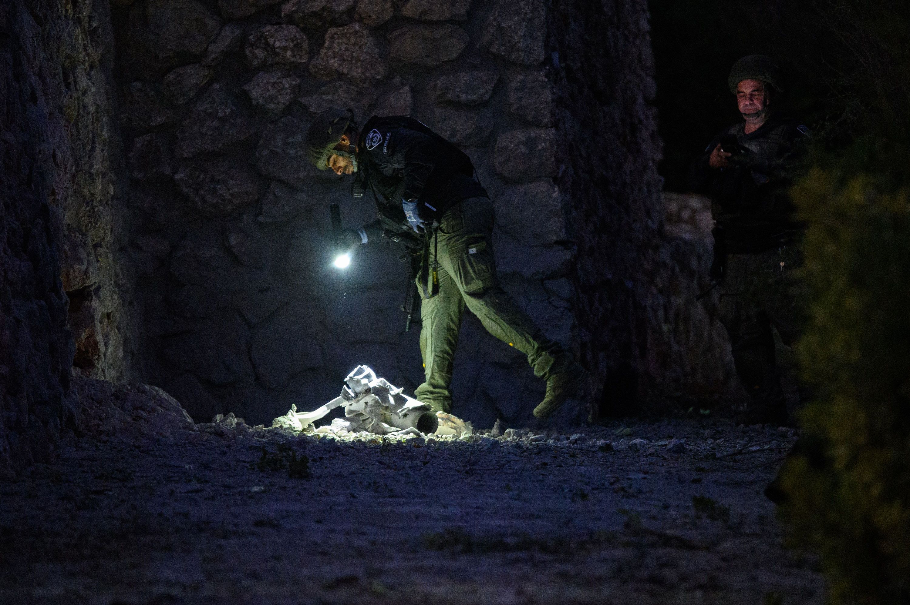 Israeli security inspects debris from a rocket in Kiryat Shmona, Israel, on October 18.