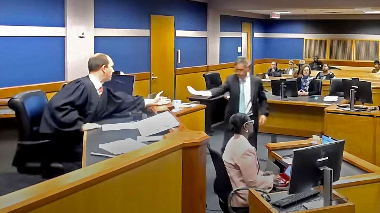 In this frame grab from video, Brian Rafferty, attorney for Sidney Powell, hands Judge Scott McAfee plea documents as Powell attends a hearing on Thursday, Oct. 19, 2023 at the Fulton County Courthouse in Atlanta.