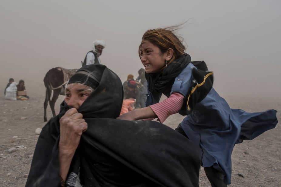 Afghan people are caught in a sandstorm after an earthquake in Afghanistan's Herat province on Thursday, October 12. <a href=