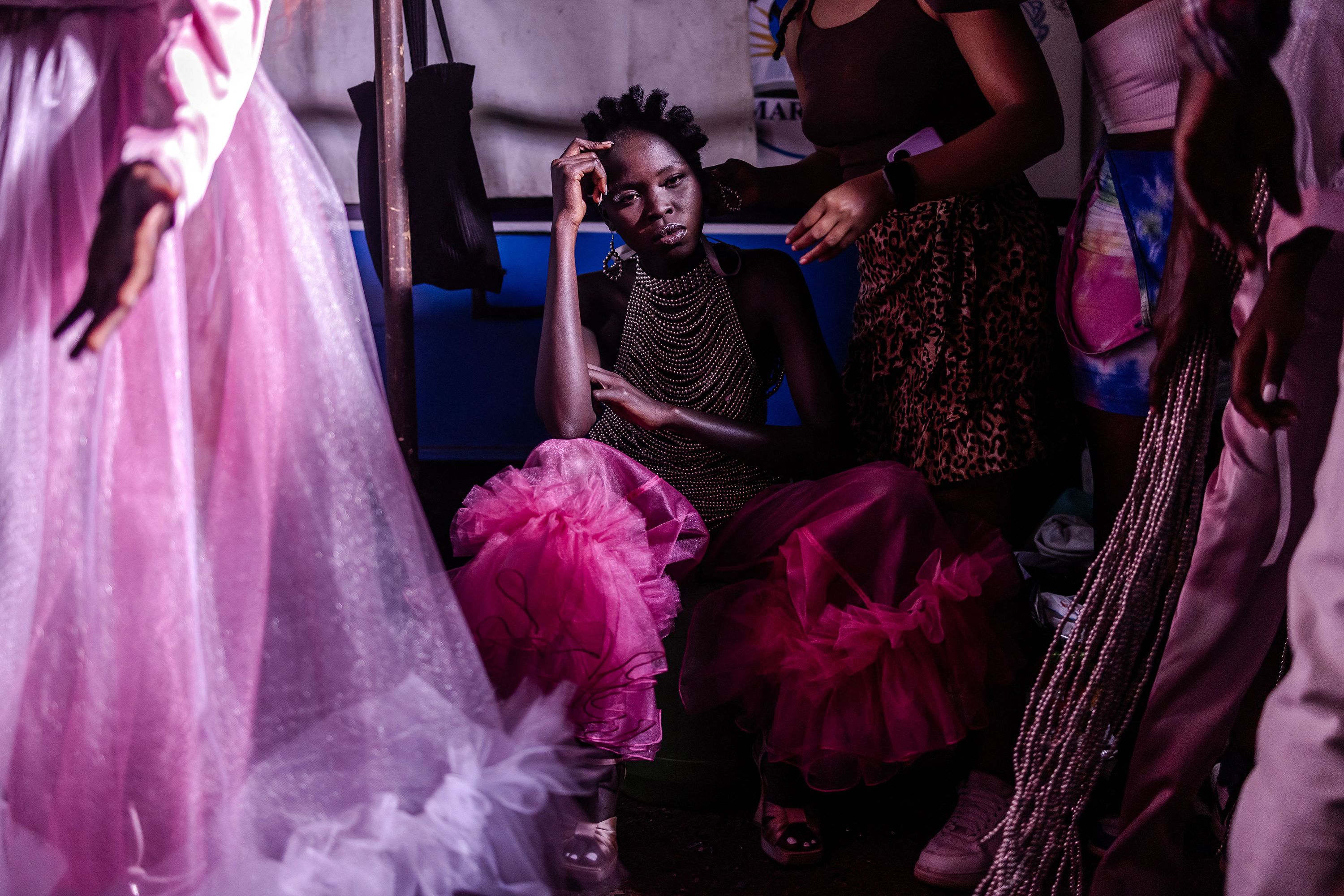 A model gets her hair done backstage at a fashion show during Kibera Fashion week.