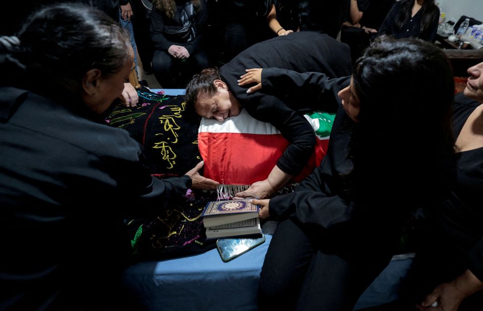 Fatma Kanso mourns over the body of her son, Issam Abdallah, during his funeral in Al Khiyam, Lebanon, on Saturday, October 14. Abdallah, a Reuters video journalist, was <a href=