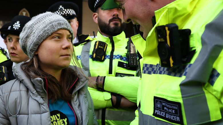 TOPSHOT - A police officer speaks to Swedish climate activist Greta Thunberg moments before she was arrested outside the InterContinental London Park Lane during the "Oily Money Out" demonstration organised by Fossil Free London and Greenpeace on the sidelines of the opening day of the Energy Intelligence Forum 2023 in London on October 17, 2023. (Photo by HENRY NICHOLLS / AFP) (Photo by HENRY NICHOLLS/AFP via Getty Images)
