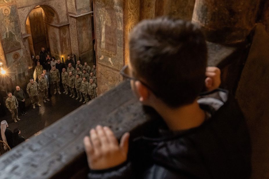 A young boy looks down at Ukrainian military chaplains during their graduation ceremony in Kyiv on Friday, October 13.