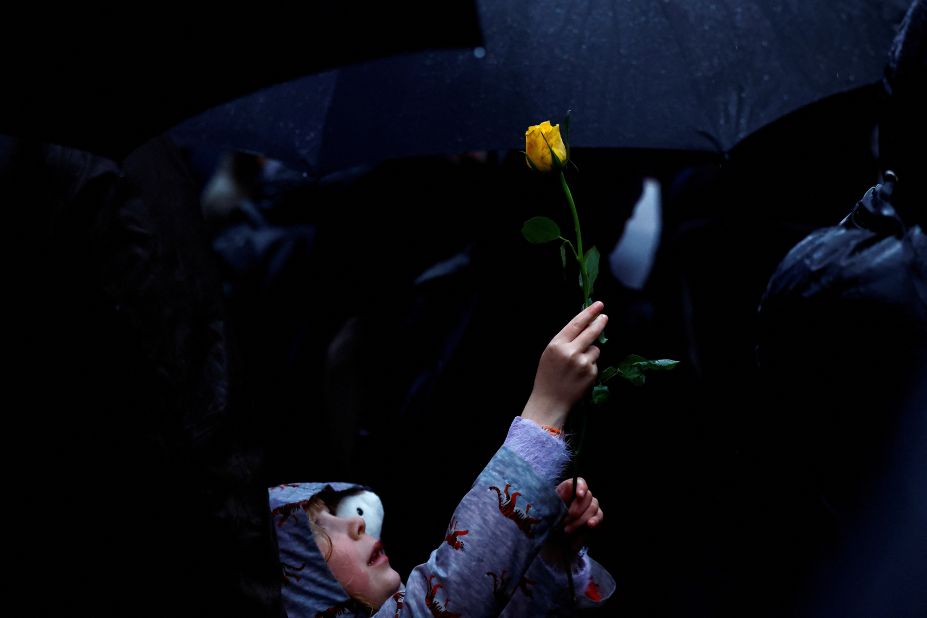 6-year-old Octavia Jeram holds up a yellow rose during a vigil held in honor of Palestinians killed in Tuesday's Al-Ahli hospital blast in London, England, on Wednesday, October 18.