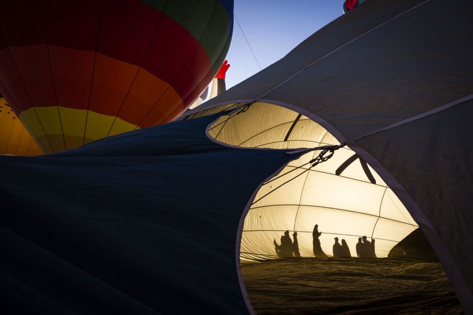 People cast shadows as they walk by a hot air balloon during the Albuquerque International Balloon Fiesta in Albuquerque, New Mexico, on Friday, October 13.