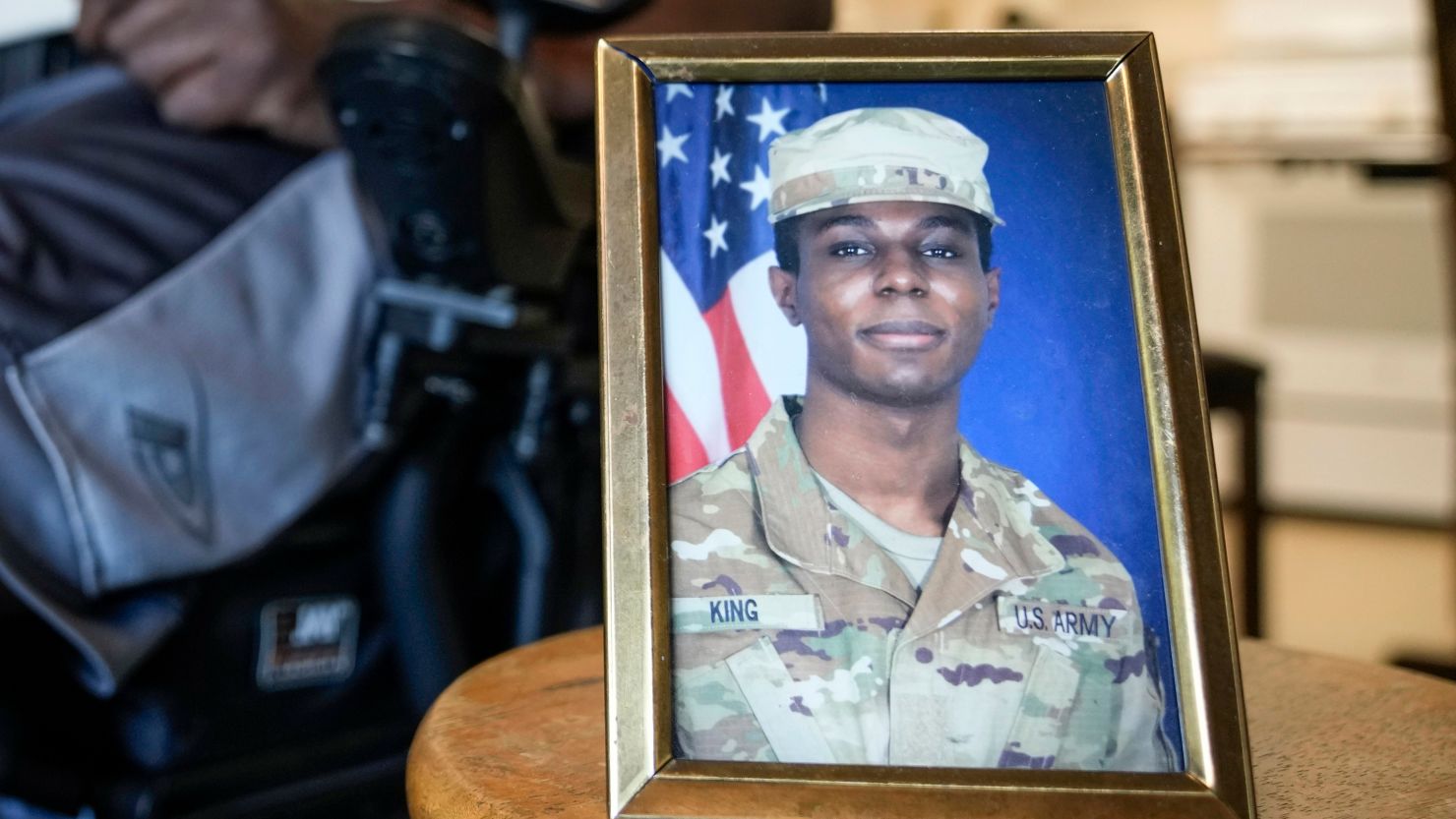 FILE - A portrait of American soldier Travis King is displayed as his grandfather, Carl Gates, talks about his grandson on July 19, 2023, in Kenosha, Wis. The Biden administration is extending for another year a ban on the use of U.S. passports for travel to North Korea, the State Department said Tuesday. The latest extension comes as tensions with North Korea are rising over its nuclear and ballistic missile programs and the uncertain status of Travis King, a U.S. service member who last month entered the country through its heavily armed border. (AP Photo/Morry Gash, File)