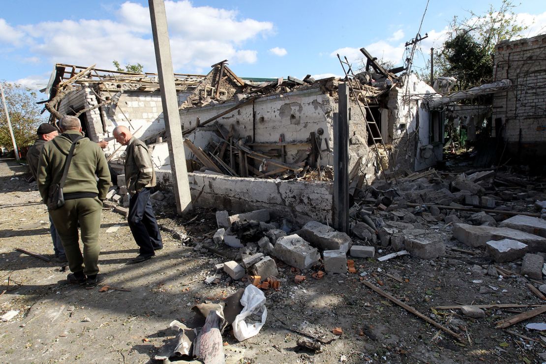 Hombres se encuentran afuera de una casa destruida en el ataque con cohetes rusos que tuvo lugar el miércoles 18 de octubre por la mañana en Obukhivka, región de Dnipropetrovsk, Ucrania central.
