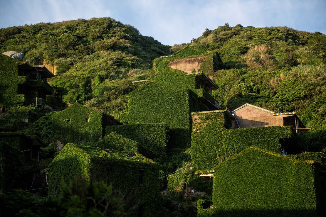 This picture taken on June 1, 2018 shows abandoned village houses covered with overgrown vegetation in Houtouwan on Shengshan island, China's eastern Zhejiang province. Houtouwan was a thriving fishing community of sturdy brick homes that climb up the steeply hilled island of Shenghshan, but is now abandoned, with entire houses completely overgrown as if vacuum-sealed in a lush layer of green. (Photo by Johannes EISELE / AFP) (Photo by JOHANNES EISELE/AFP via Getty Images)