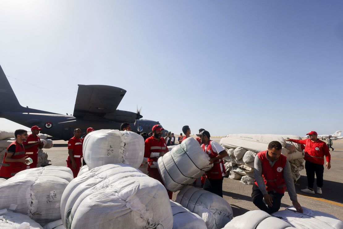 Egyptian Red Crescent workers coordinate aid for Gaza, as UN Secretary-General Antonio Guterres speaks to the media at Al Arish Airport in Egypt on Friday, October 20, 2023.