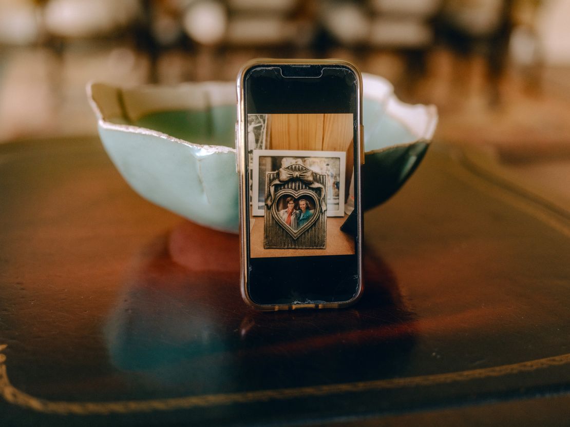 A photo of Mercedes Virgili, left, and Charlotte Hauptman is seen on Hauptman's phone. The framed photo is on display in the Virgili family home in Secchiano, Italy.