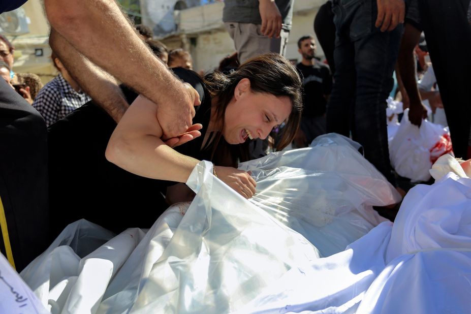 A Palestinian woman mourns over the bodies of her relatives who were killed an Israeli airstrike that hit a Greek Orthodox church in Gaza City on Friday, October 20.
