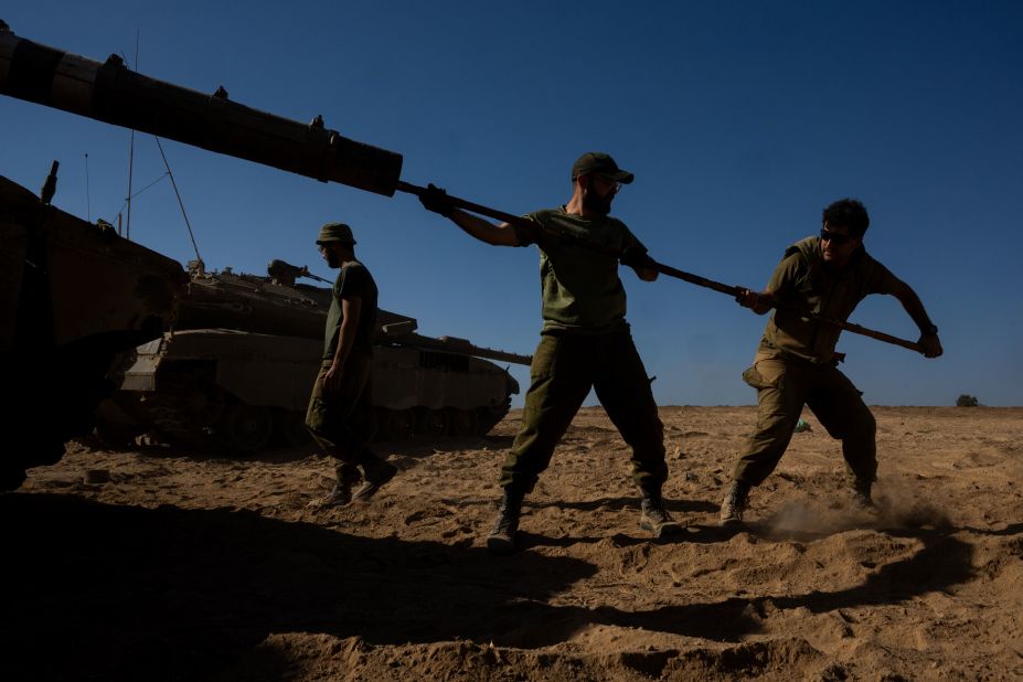 IDF soldiers clean the barrel of a tank in southern Israel on Saturday, October 21.