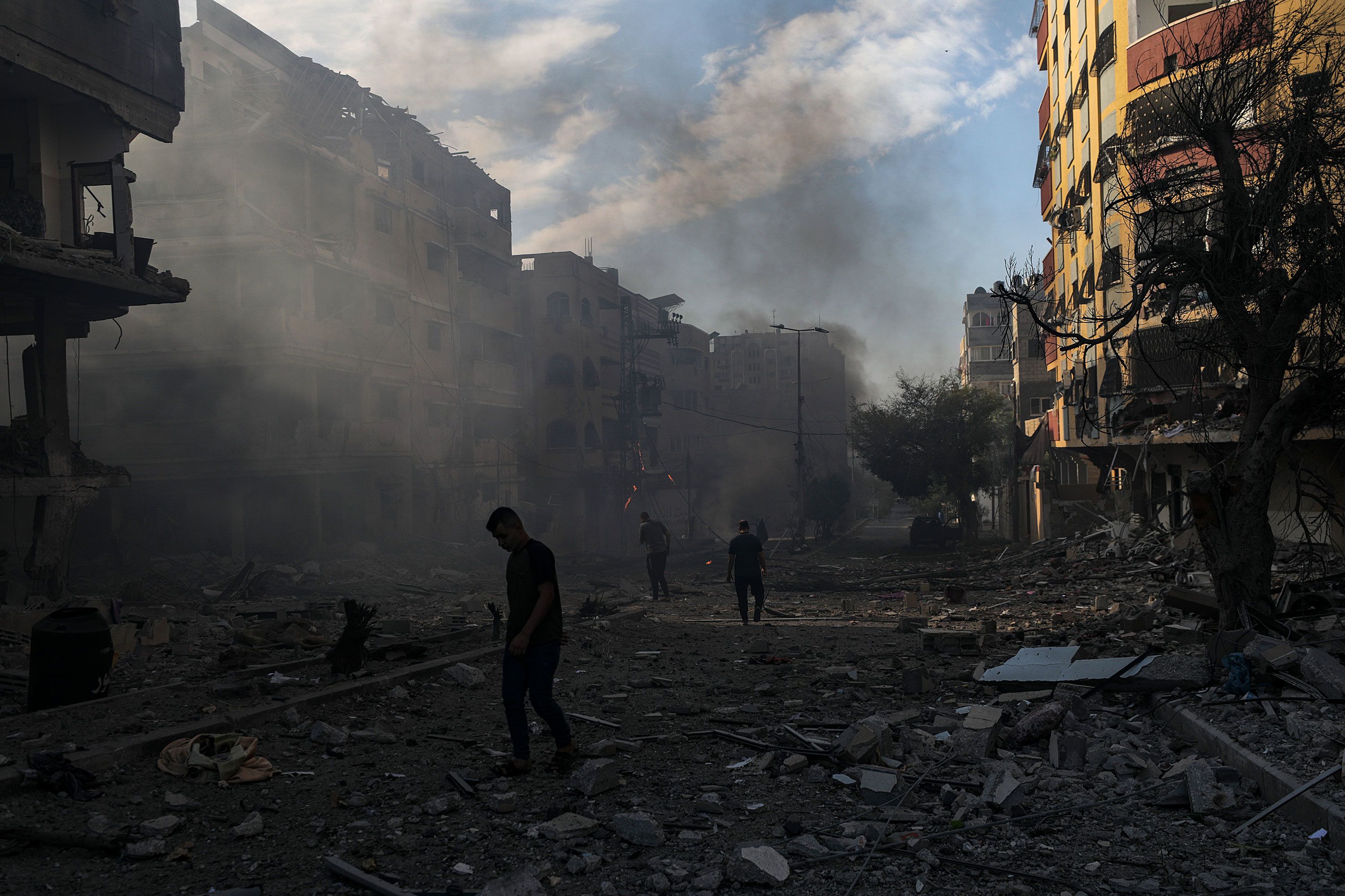 Palestinians inspect a destroyed area following an Israeli airstrike in Gaza on October 21.